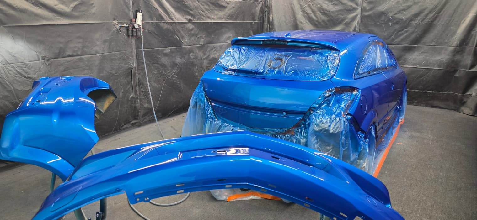 Car masked up in the spray booth mid-respray